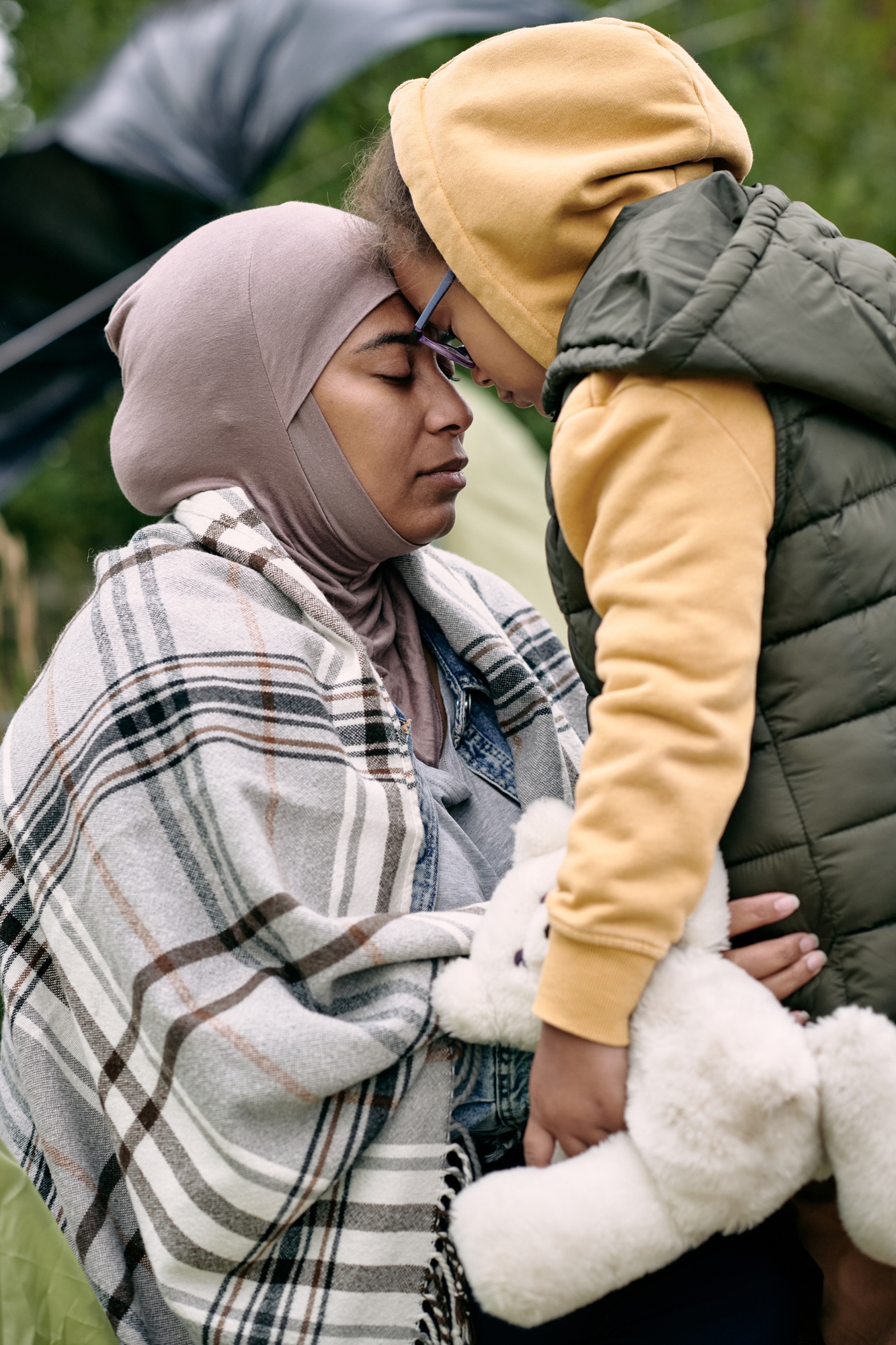 Young refugee female and her little daughter with toy